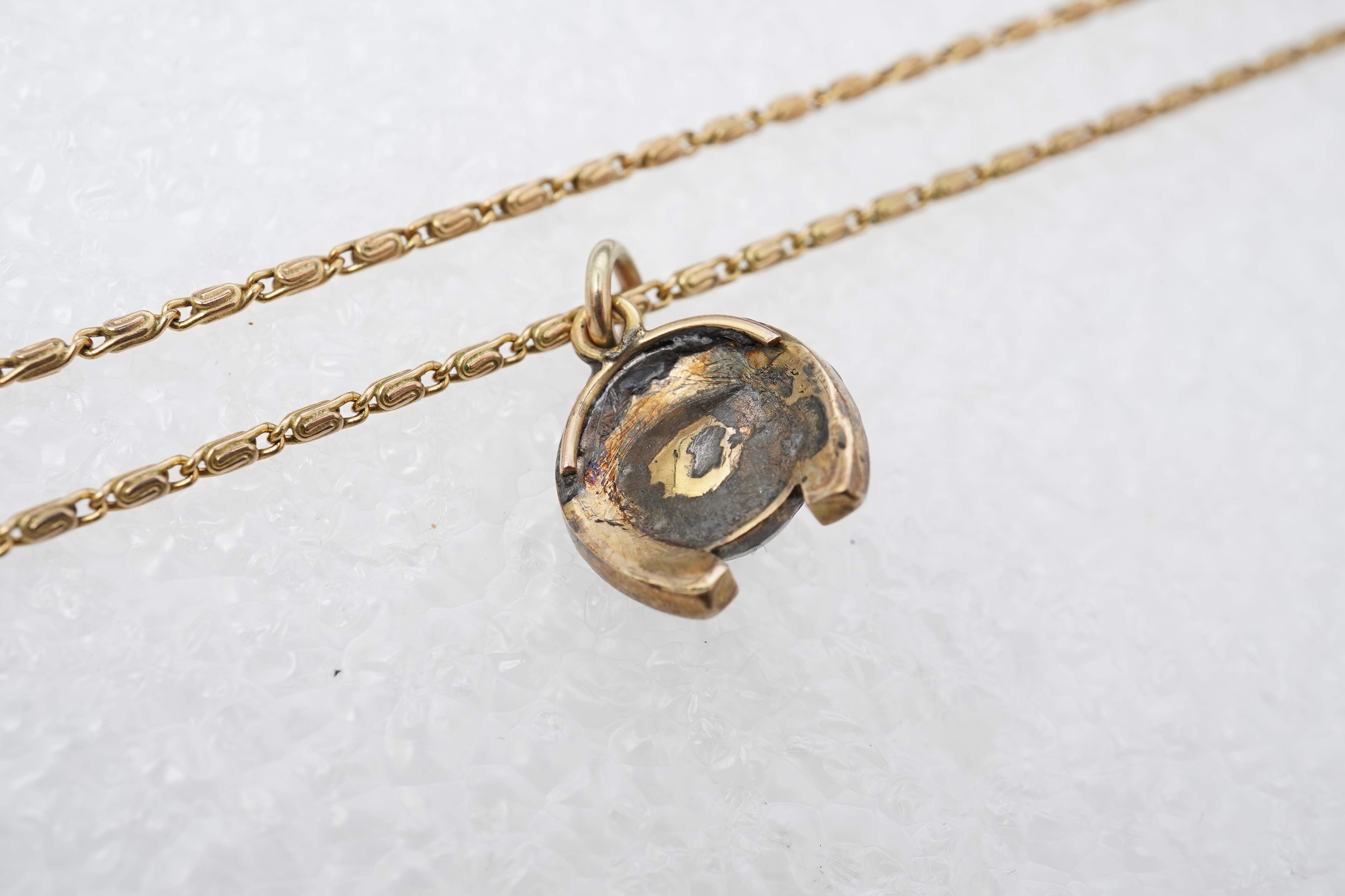 A yellow metal, cat's eye quartz and rose cut diamond cluster set horseshoe pendent, 11mm, together with a 9ct gold chain, 41cm, gross weight 5 grams.